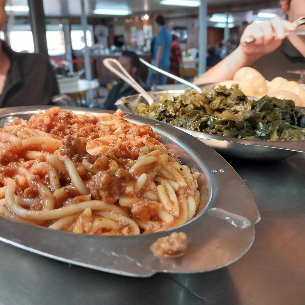 Scratch-made spaghetti and collard greens on a lazy-Susan table